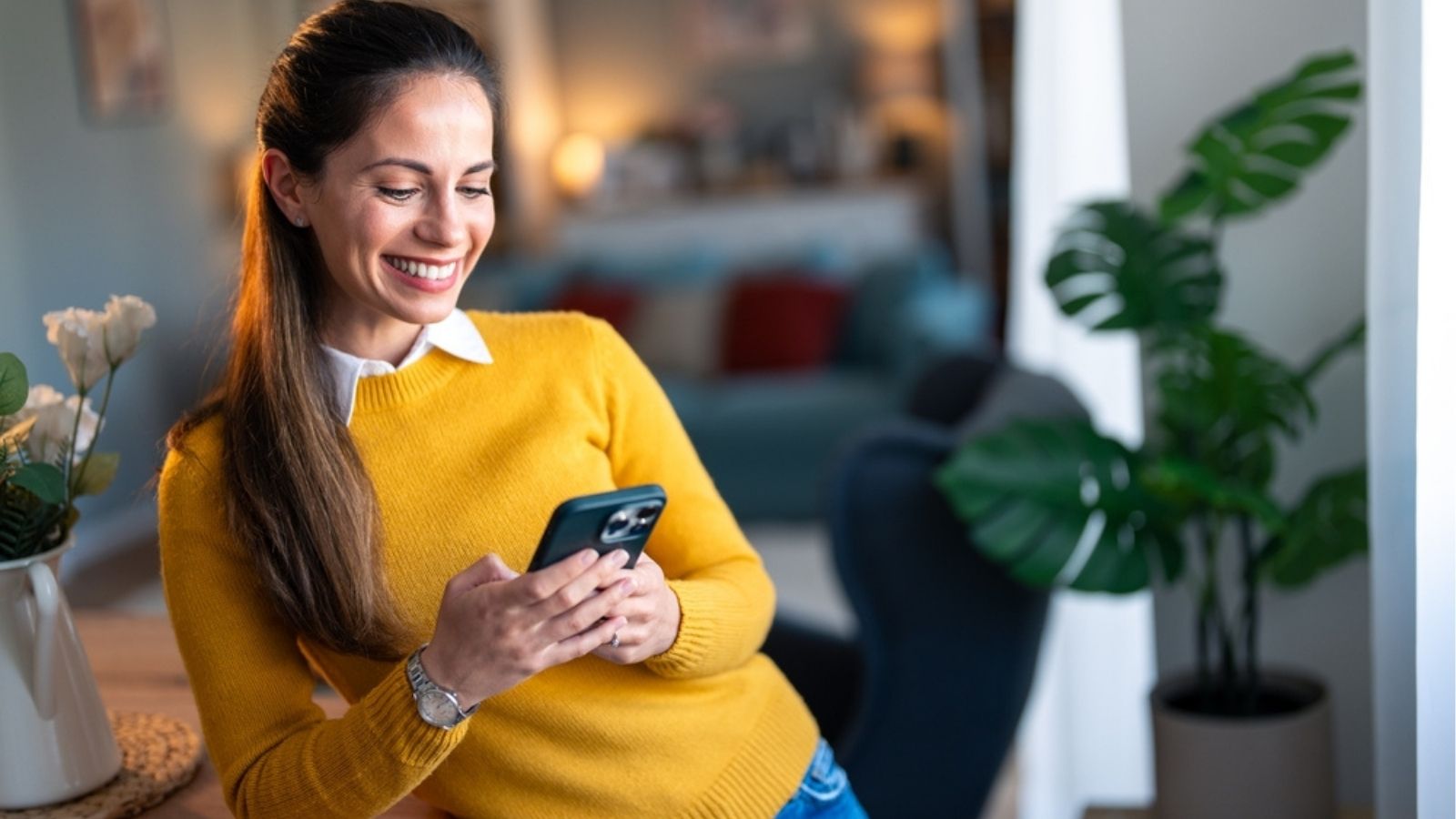 Smartfon z powiadomieniem o wpływie premii na konto w aplikacji bankowej